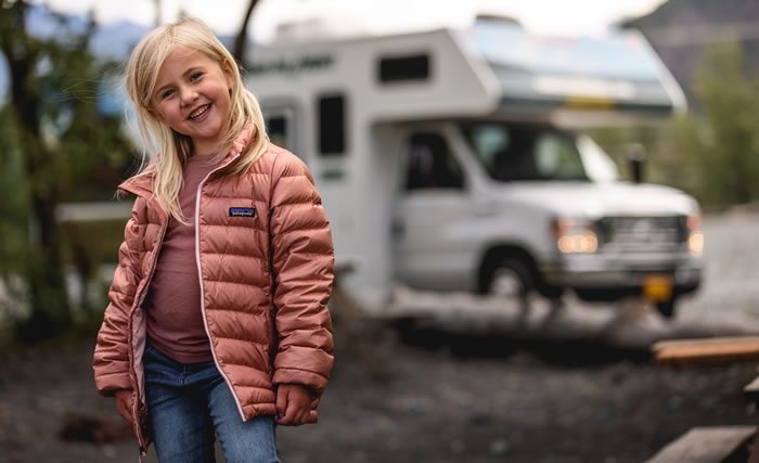 Young girl standing in front of RV