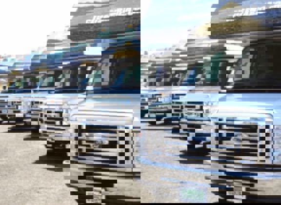 Front view of a row of RVs in a parking lot.