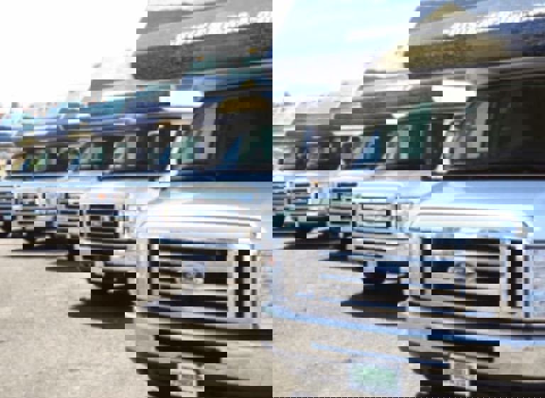 Front view of a row of RVs in a parking lot.